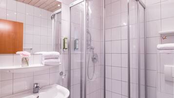 Ein modernes Badezimmer mit einer Duschkabine, einem Waschbecken und einer Toilette.