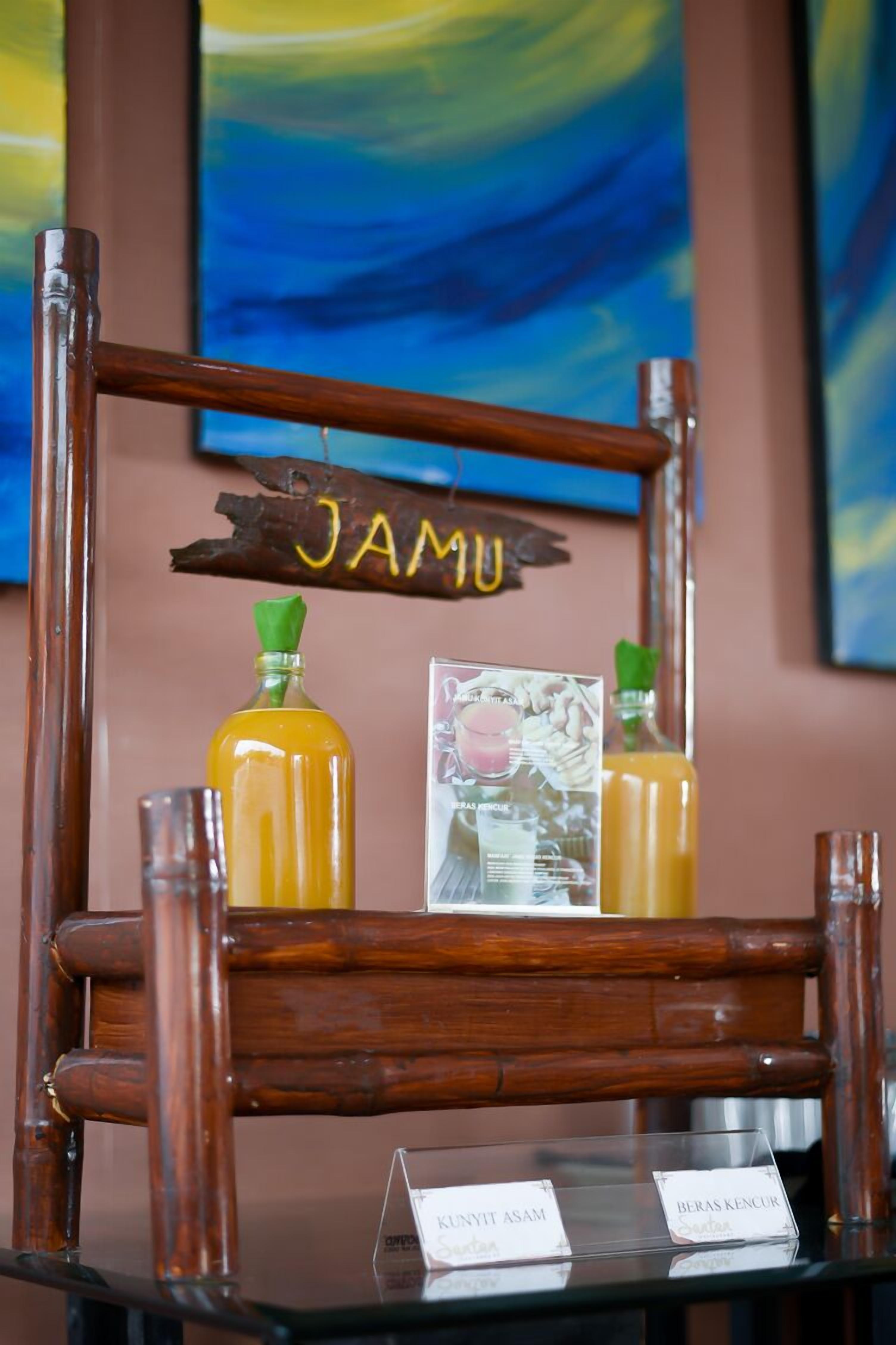 A wooden chair with a sign reading "JAMU" and two bottles on it.