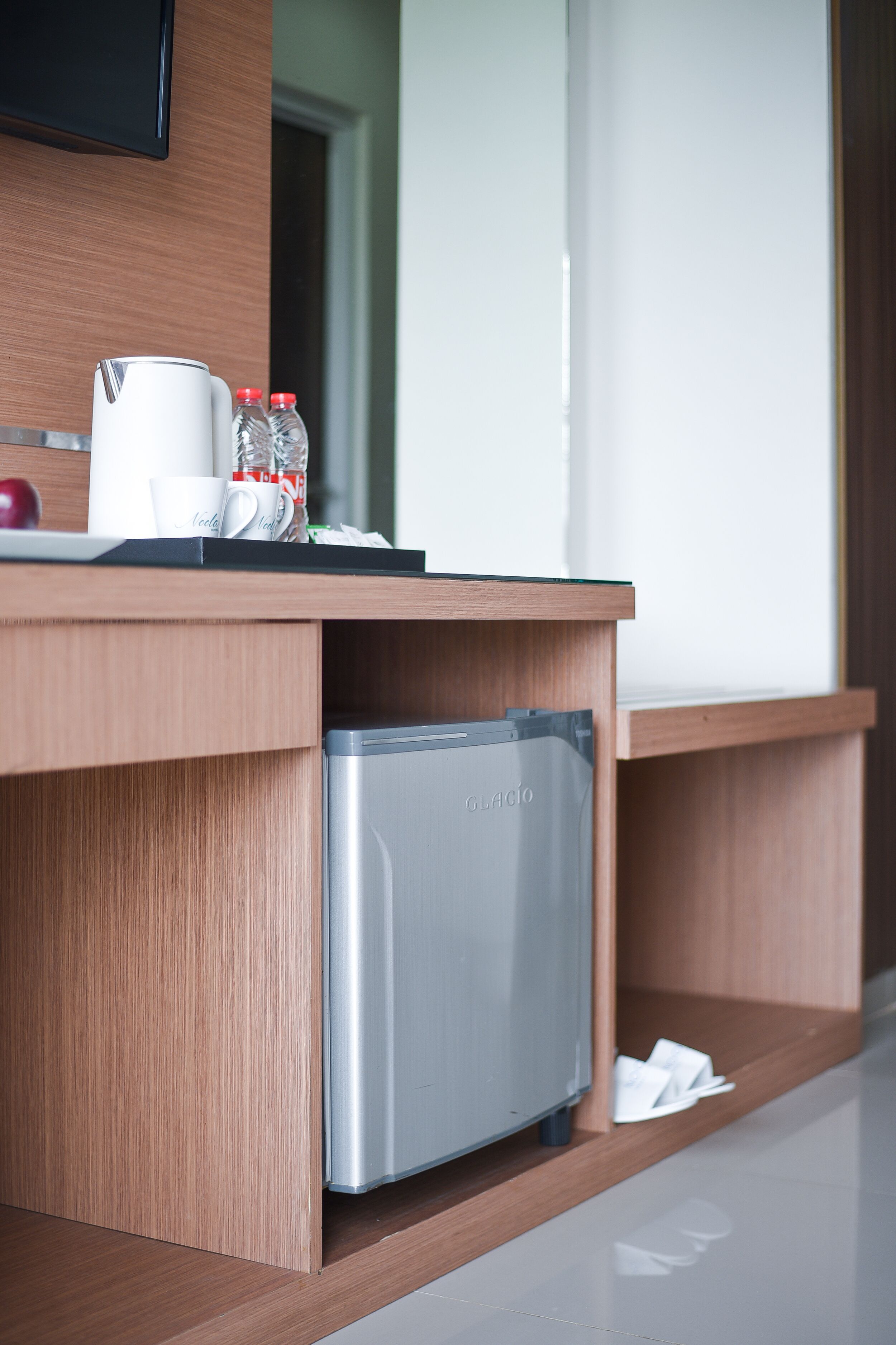 A modern kitchen area with a built-in refrigerator, a coffee maker, and a water dispenser on the countertop.