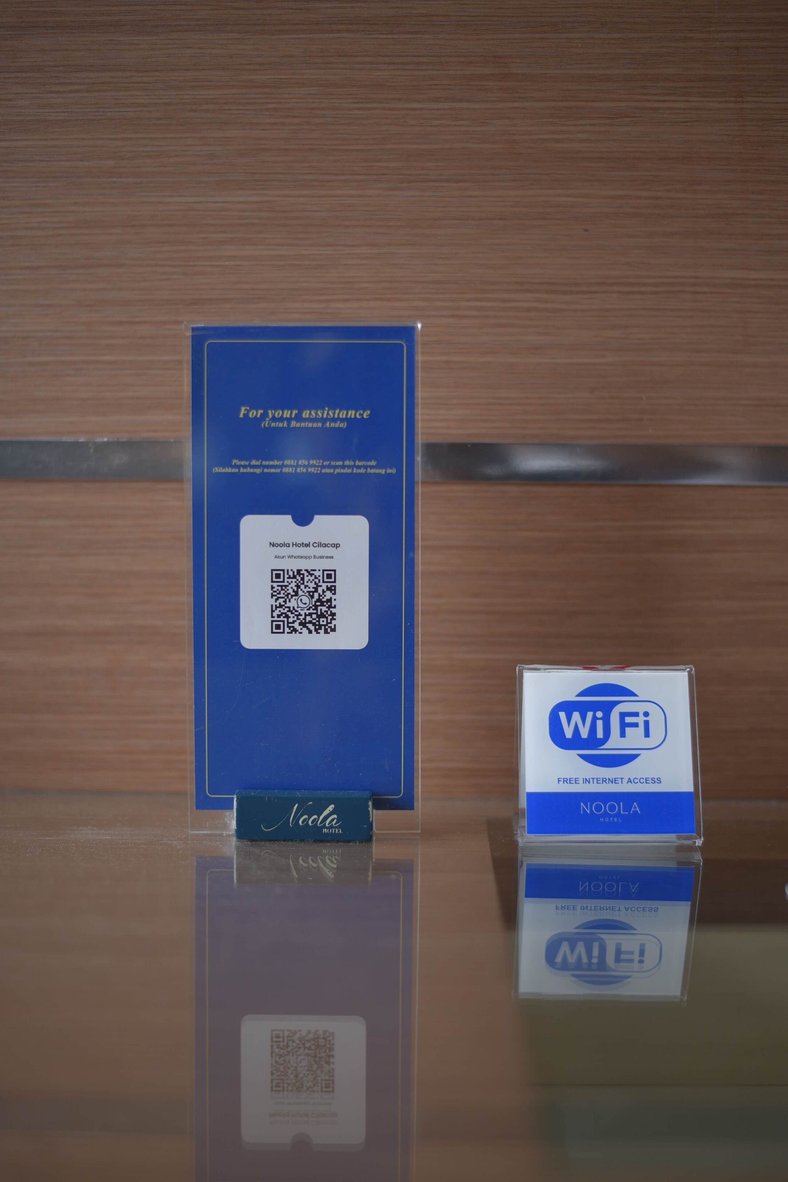A blue sign with a QR code and text for Noola Hotel WiFi access.