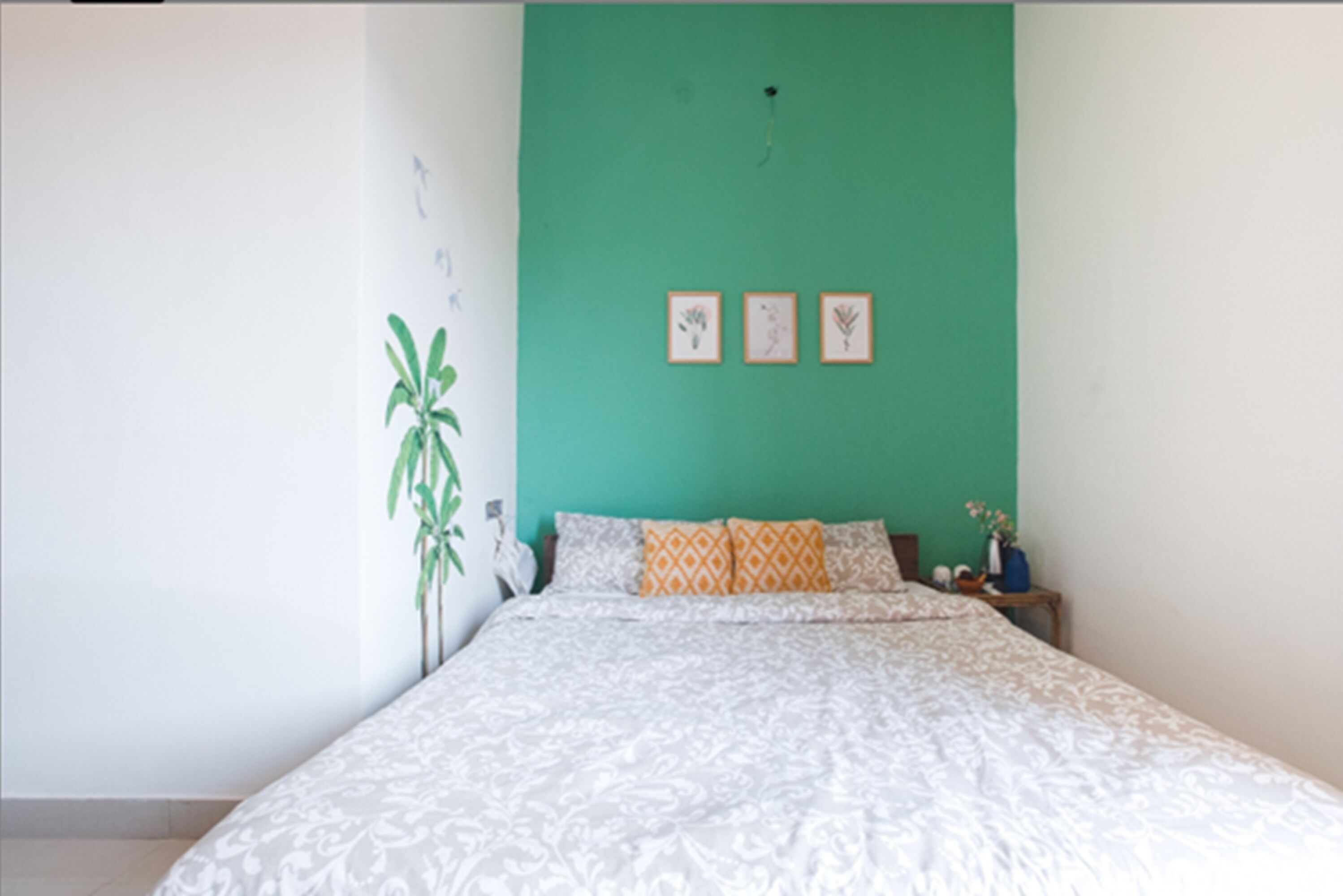 Een slaapkamer met een bed, een nachtkastje en een wandplank.