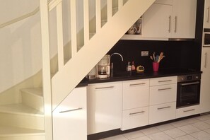 Enjoy cooking in this well-equipped kitchen with an oven, coffee maker, and stainless steel range hood.