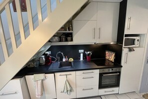 Kitchen features an oven, microwave, sink, and various appliances.