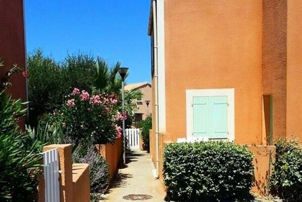 Stroll through lush gardens and enter a charming residential haven with an entrance.