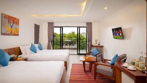 A hotel room with two beds, a desk, a chair, and a view of greenery outside. - Angkor Style Resort (Siem Reap)