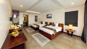 A hotel room with two beds, a desk, a lamp, and a view of the city. - Angkor Style Resort (Siem Reap)