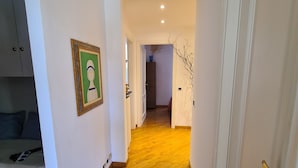 A hallway with wooden flooring, white walls, and a door on the right. - Santa in Caruggio- PortofinoVacanze (Santa Margherita Ligure)