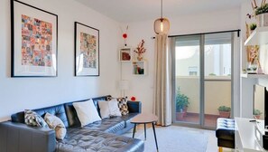 A modern living room with a leather sofa, framed artwork, a small table, and a balcony with potted plants. - Unique accommodation with a private pool, sea view, terrace, 300m to Aldea Beach (Manilva)