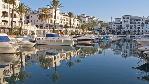 A marina with boats docked, surrounded by white buildings with balconies and palm trees. - Unique accommodation with a private pool, sea view, terrace, 300m to Aldea Beach (Manilva)