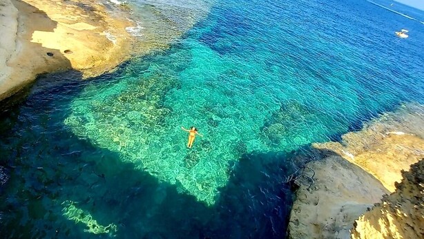 A coastal area with clear turquoise waters and rocky terrain. - Del Mar Apartment! (Iż-Żebbuġ)