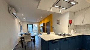 A modern kitchen with blue cabinets, a white countertop, and a gas stove. - Del Mar Apartment! (Iż-Żebbuġ)