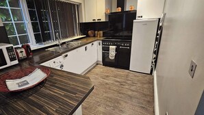 Eine kompakte Küche mit Mikrowelle, Herd, Spüle und Kühlschrank.