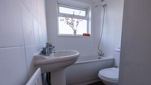A bathroom with a white sink, bathtub, and toilet. - Immaculate 2-bed Apartment in Dartford (Dartford)