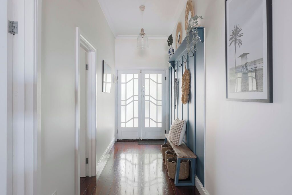 A hallway with a bench, a door, and wall-mounted decor.