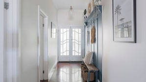 A hallway with a bench, a door, and wall-mounted decor. - View Point: Ocean Views & Near CBD (Burnie)