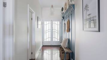 A hallway with a bench, a door, and wall-mounted decor.