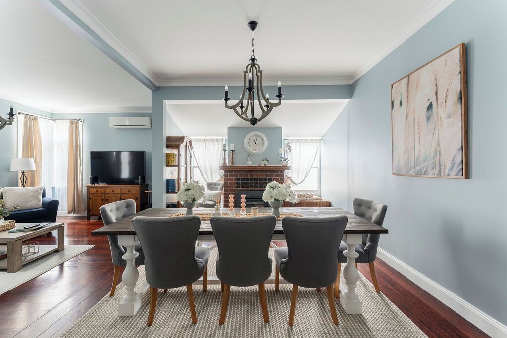 A dining area with a chandelier, a fireplace, and a television in the background.