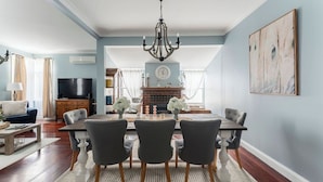 A dining area with a chandelier, a fireplace, and a television in the background. - View Point: Ocean Views & Near CBD (Burnie)