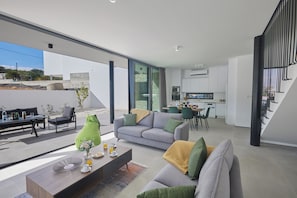 Un espace de vie moderne comprenant un canapé, une table basse et un coin repas.