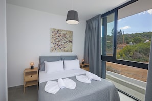 Une chambre dâhĂŽtel moderne avec un grand lit, un tableau au mur et une vue sur la campagne.