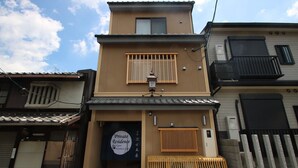 En tvåvåningsbyggnad med en skylt som visar texten ”Privatbostad, Kyoto”.
