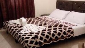 Una cama con una colcha estampada y una almohada blanca.