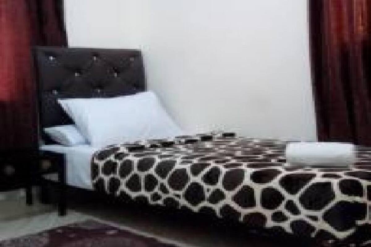 A bedroom with a bed, a nightstand, and a dark-colored headboard.