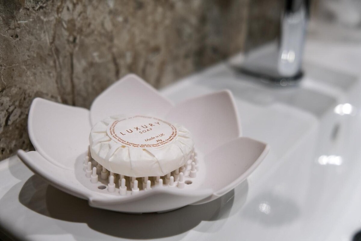 A luxury soap bar in a lotus-shaped container on a white surface.