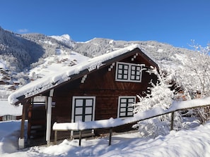 A wooden cabin with two windows, surrounded by snow-covered trees and mountains. - Family Chalet for 8/9, 5 mins to Village Center, Mountain Views, WiFi (Arêches-Beaufort)