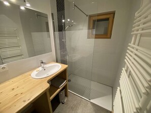 A modern bathroom with a wooden vanity, a glass shower enclosure, and a white radiator. - Family Chalet for 8/9, 5 mins to Village Center, Mountain Views, WiFi (Arêches-Beaufort)