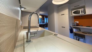 A modern kitchen with a stainless steel faucet, a built-in microwave, and a light fixture above the sink. - Family Chalet for 8/9, 5 mins to Village Center, Mountain Views, WiFi (Arêches-Beaufort)