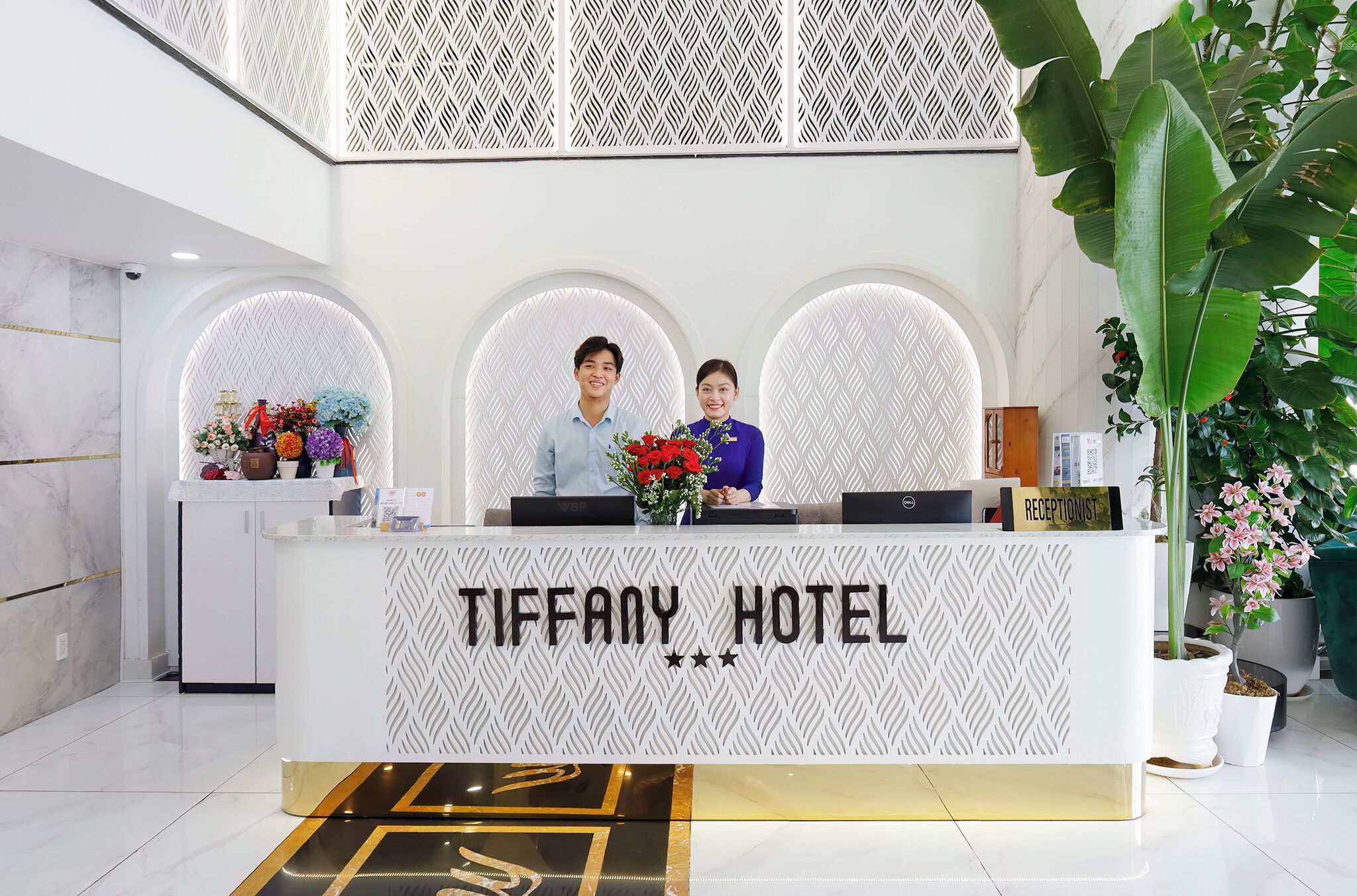 A reception desk with a sign reading "TIFFANY HOTEL".