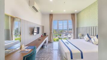 A hotel room with a bed, a desk, a chair, a TV, and a window with a view of the outside.