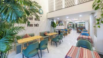 A hotel lobby with seating areas, a reception desk, and a patterned wall.