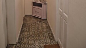 A narrow hallway with patterned floor tiles, a small cabinet with decorative items, and a door on the right. - Beaucaire Cocoon 1 /quais/cité Médiévale/nature (Beaucaire)