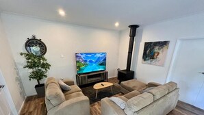A living room with a sofa set, a TV, a plant, and a fireplace. - Berghofen ..Tamborine Mountain Family escape including your furry friends! (Tamborine Mountain)