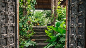 A rustic wooden staircase leading to a covered area with a metal door on either side. - Sānti Beach House  (Weligama)