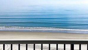 A beach view with calm water and a clear sky. - Oceanfront Modern Condo w 8 Water Features (Myrtle Beach)