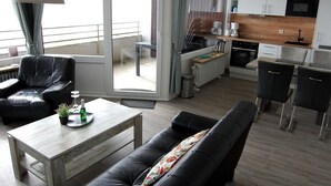 Una sala moderna con un sofá, una mesa de centro y un comedor con una mesa y sillas.