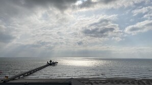 Un muelle que se adentra en aguas tranquilas bajo un cielo nublado.