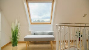 A room with a skylight, a radiator, a bench, and a white crib. - House Deichgraf Whg. 12 (Grömitz)