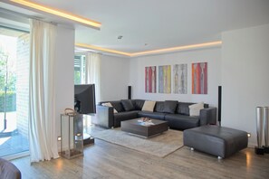 A modern living room with a sectional sofa, a coffee table, and a fireplace. - Sealounge Whg. 1 Inkl. Wlan (Grömitz)