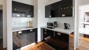 Una cucina moderna con mobili neri, un piano di lavoro bianco e una macchina da caffè.
