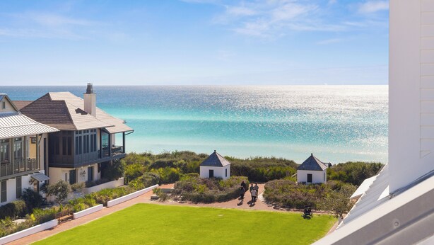 Ein Küstengrundstück mit einem großen Haus, zwei kleineren Gebäuden und freiem Blick auf das Meer.