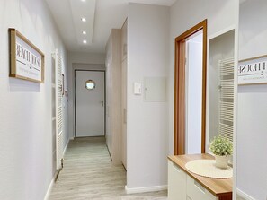 A hallway with a wooden door, a mirror, and a sign on the wall.