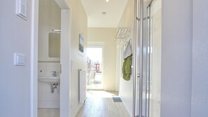 A modern bathroom with a sink, mirror, and glass shower enclosure.