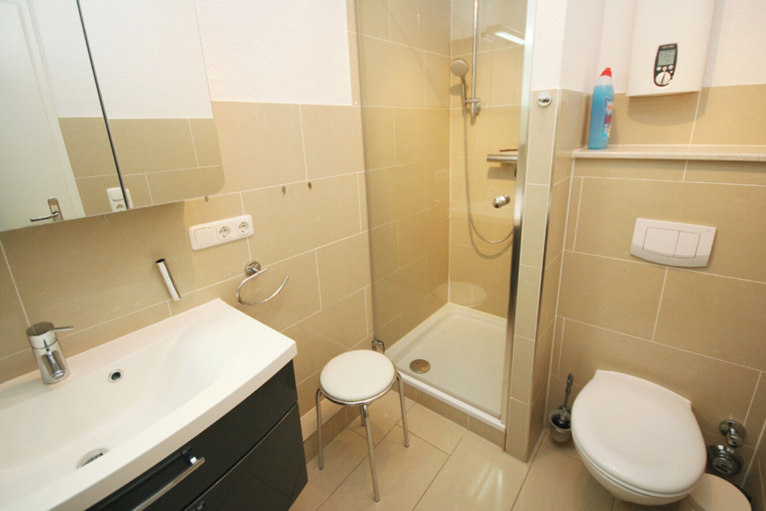 Un baño con lavamanos, inodoro y ducha.