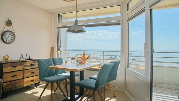 A modern kitchen with a dining area, large windows, and a view of the sea. - Grömitz-center I App. 657 Inkl. Wlan (Grömitz)