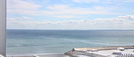Un edificio moderno con terraza en la azotea y vistas a la playa y al mar.