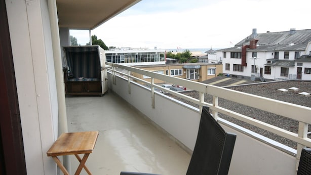 En balkon med udsigt til bygninger og en strand.